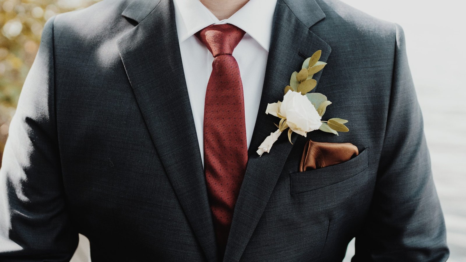 A beautiful shot of the groom with a white flower on a suit